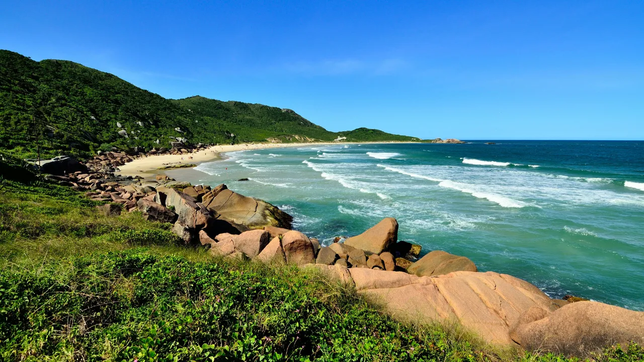 Vista panorâmica da Praia de Florianópolis, mostrando o mar azul-turquesa e a orla bem estruturada