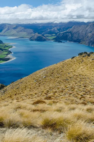 Vista panorâmica de montanha icônica da Nova Zelândia com lagos azuis e vales verdejantes, representando os diversos pontos turísticos do país"
