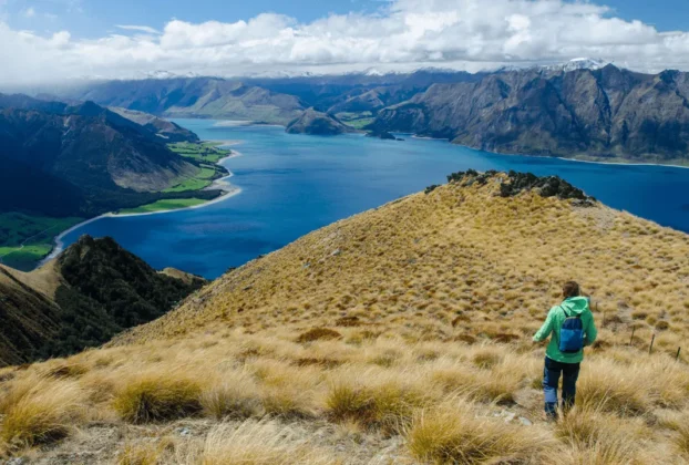 Vista panorâmica de montanha icônica da Nova Zelândia com lagos azuis e vales verdejantes, representando os diversos pontos turísticos do país"